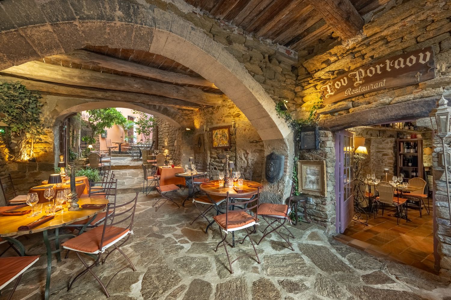 Le passage voûté vers la ruelle, avec ses tables et ses lampes